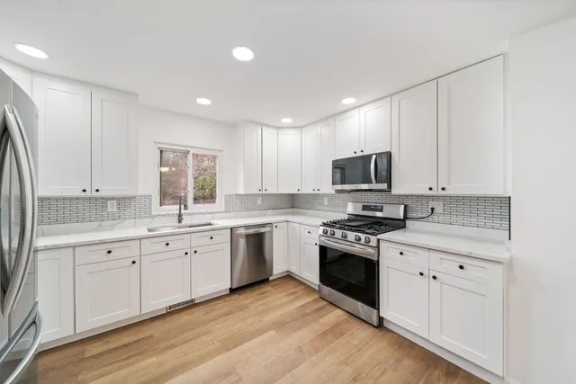 a kitchen with granite countertop a sink stainless steel appliances and cabinets