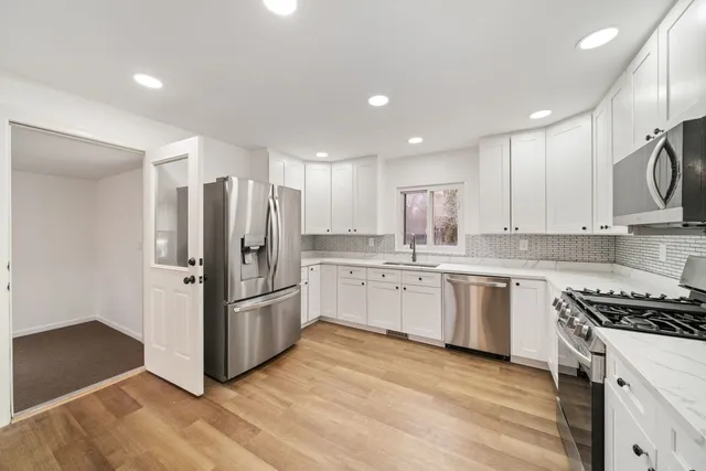 a kitchen with stainless steel appliances granite countertop a refrigerator and a stove top oven