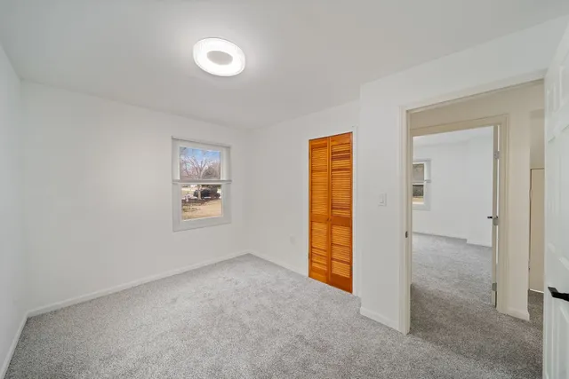 an empty room with windows and closet