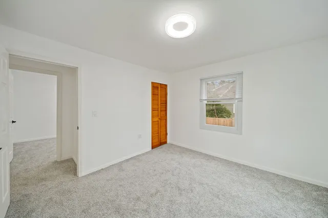 an empty room with windows and closet