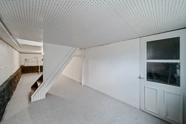 a view of an empty room with a flat screen tv and staircase