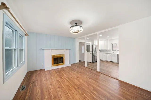 a view of a livingroom with a fireplace wooden floor and window