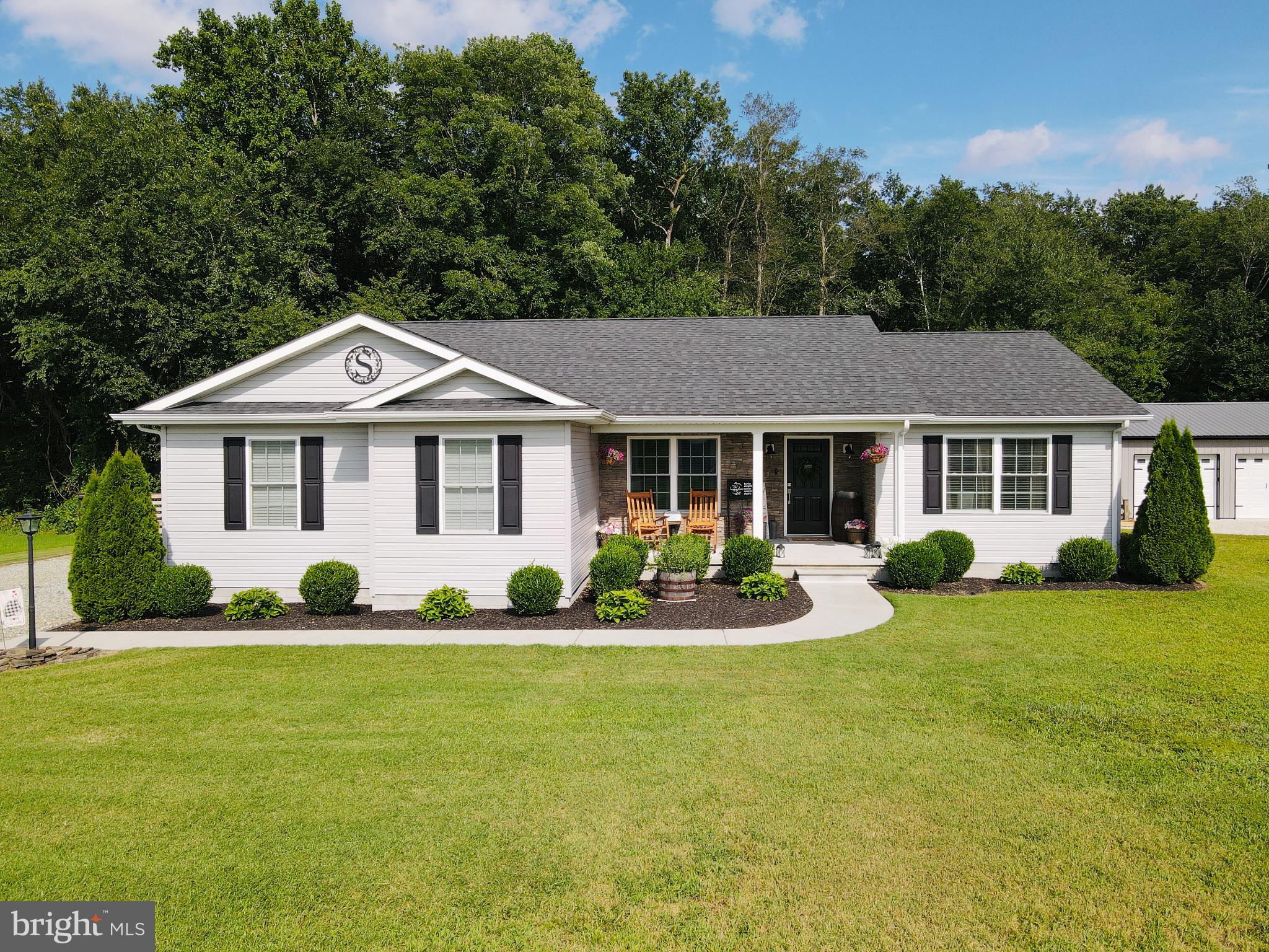 a front view of a house with yard and green space