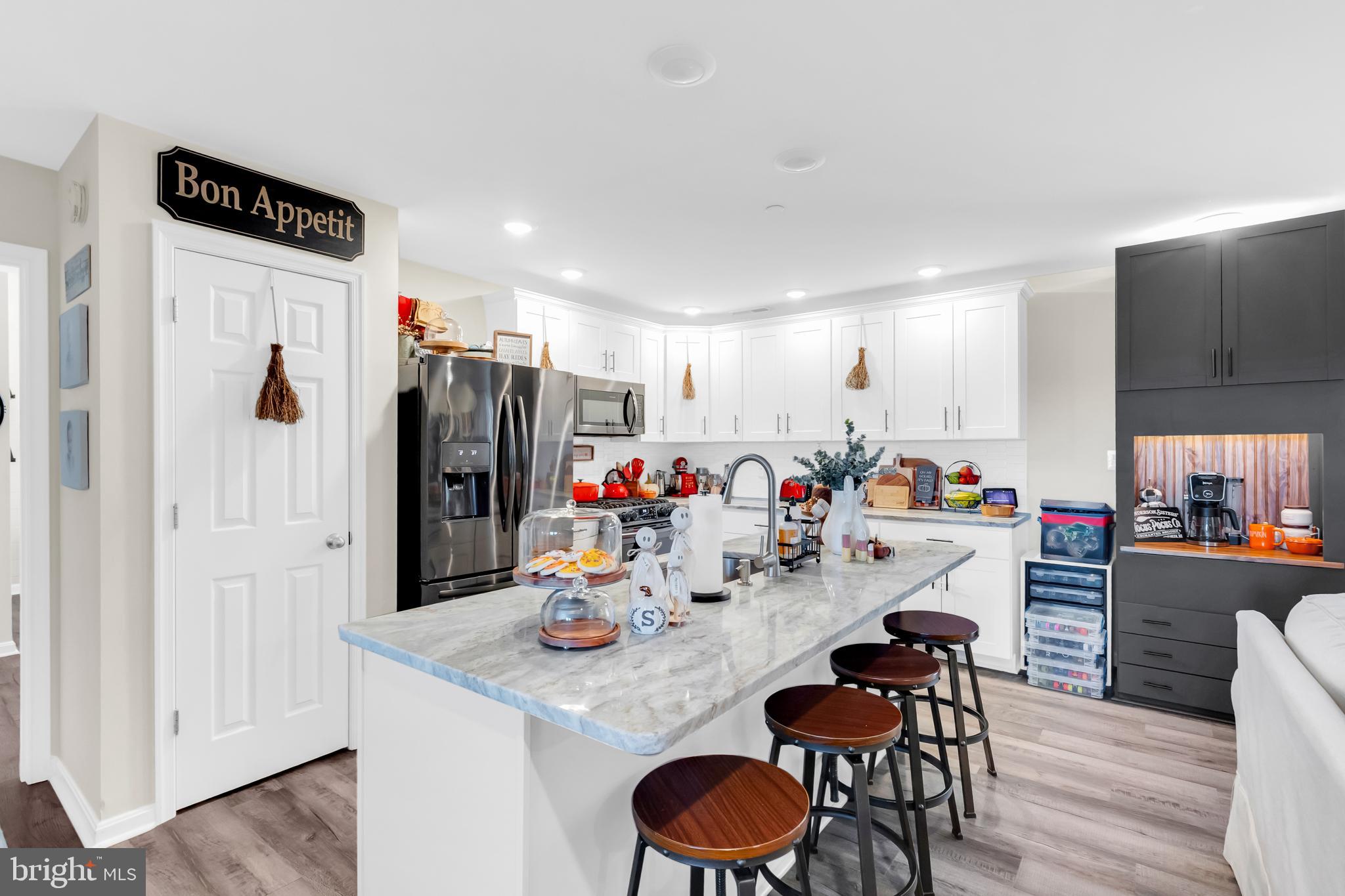 7829 New Hope Road Willards, MD 21874 - Photo 12 of 41 a kitchen with stainless steel appliances granite countertop a dining table chairs and a refrigerator a oven with wooden floor