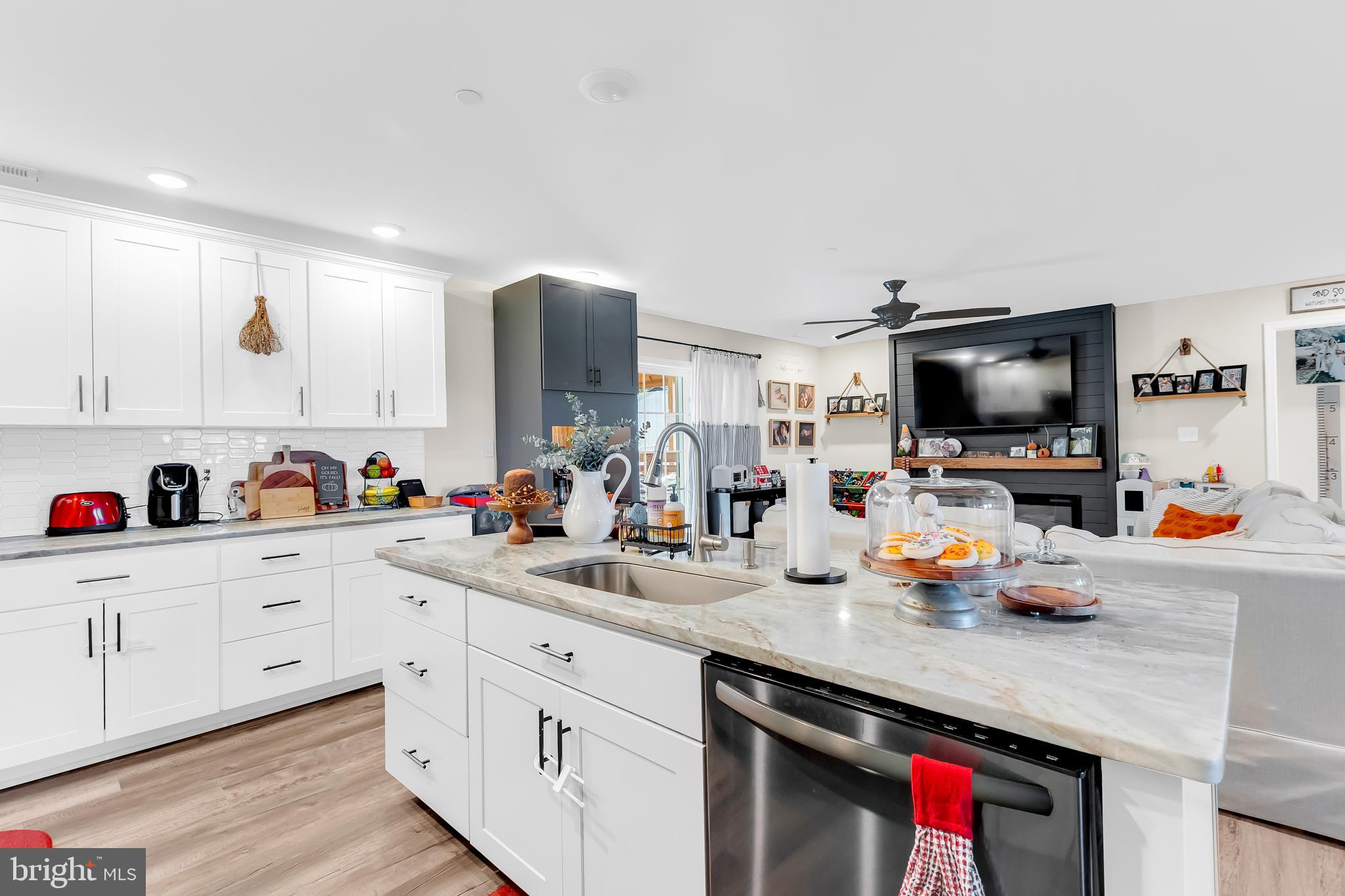 7829 New Hope Road Willards, MD 21874 - Photo 13 of 41 a kitchen with stainless steel appliances a sink dishwasher and white cabinets with wooden floor