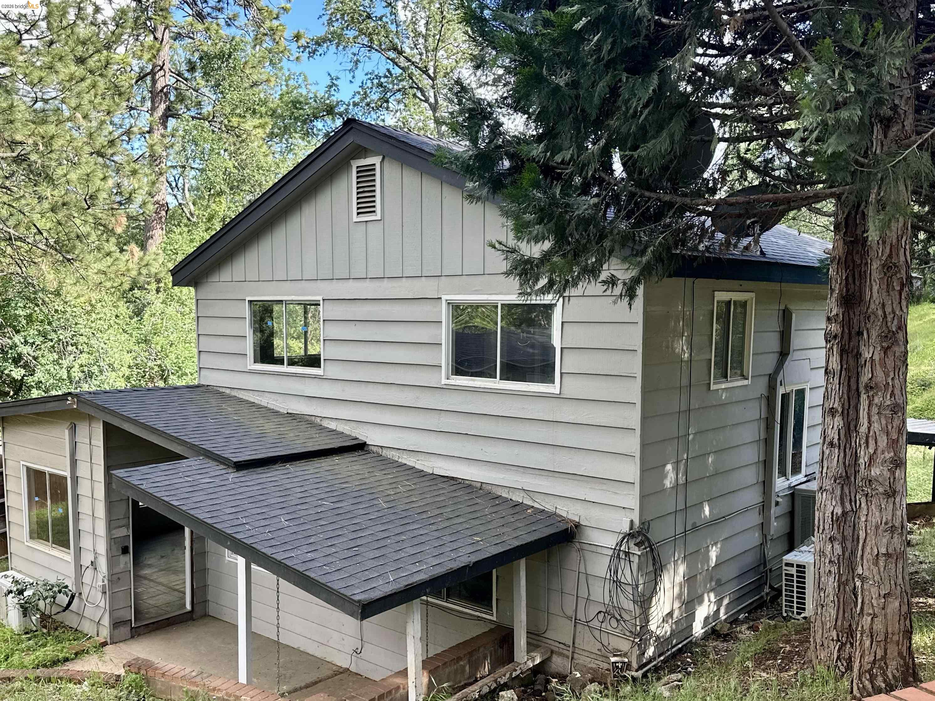 20231 Hidden Acres Road Sonora, CA 95370 - Photo 1 of 25 Multi-level residence featuring gray horizontal siding and dark gray shingle roofing