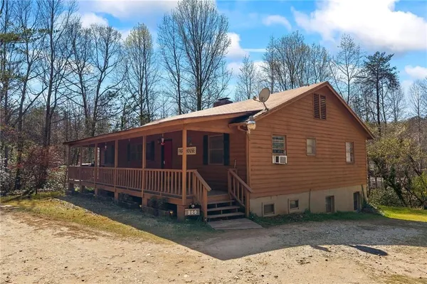 a front view of house with yard and trees around