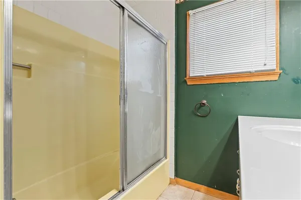 a view of an empty room with window and chandelier fan