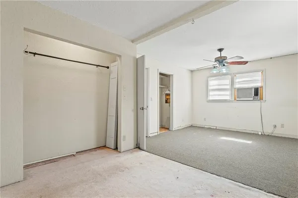 an empty room with a window and a ceiling fan