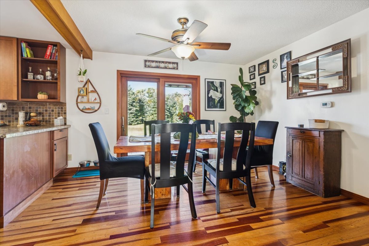 12641 Willow Lane Genoa, IL 60135 - Photo 11 of 29 a dining room with wooden floor a glass table and chairs