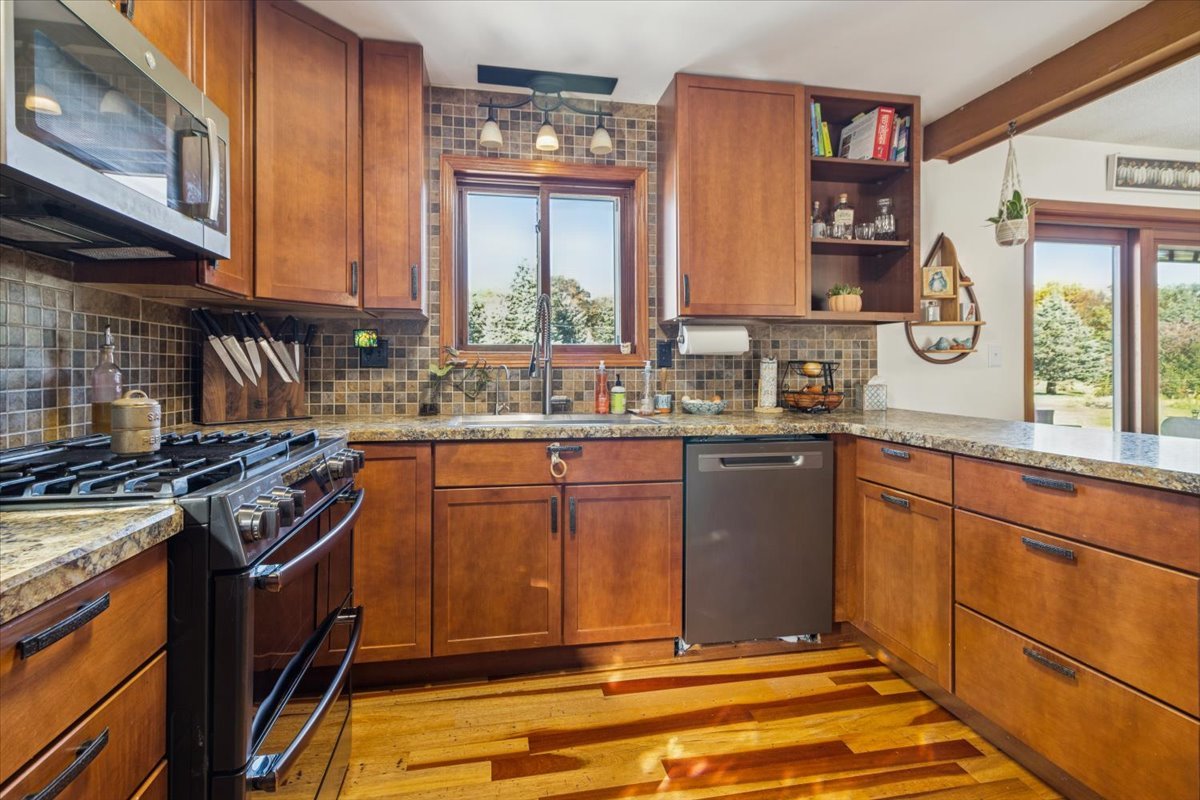 12641 Willow Lane Genoa, IL 60135 - Photo 14 of 29 a kitchen with stainless steel appliances granite countertop a stove a sink and a microwave