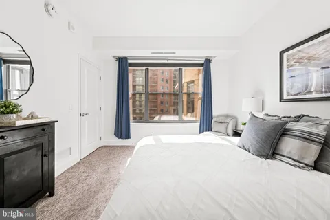 a bedroom with a bed and a large window