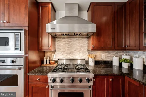 a kitchen with stainless steel appliances granite countertop a stove and a microwave