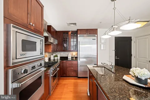 a kitchen with stainless steel appliances granite countertop a sink stove and refrigerator