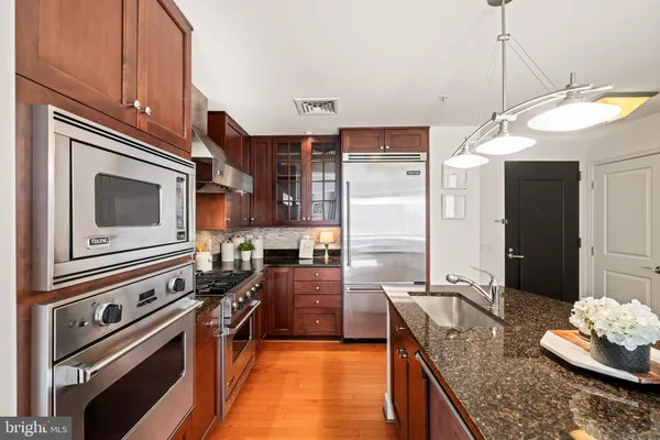 a kitchen with stainless steel appliances granite countertop a sink stove and refrigerator