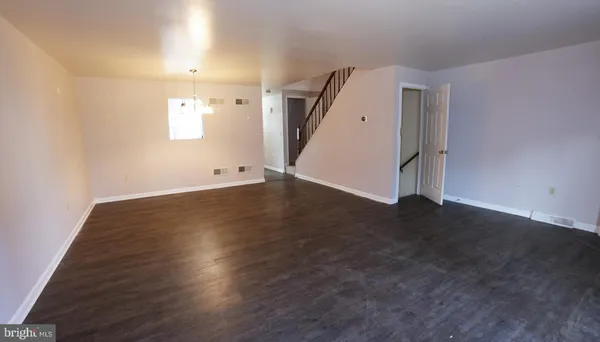 an empty room with wooden floor and white walls