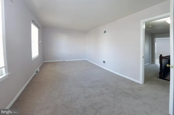 an empty room with windows and closet