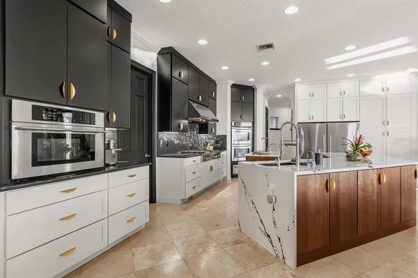 a view of kitchen with stainless steel appliances granite countertop a refrigerator and a sink