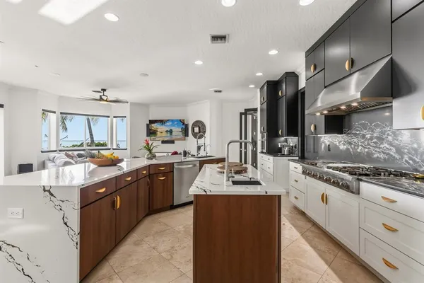 a kitchen with stainless steel appliances granite countertop a sink stove and refrigerator