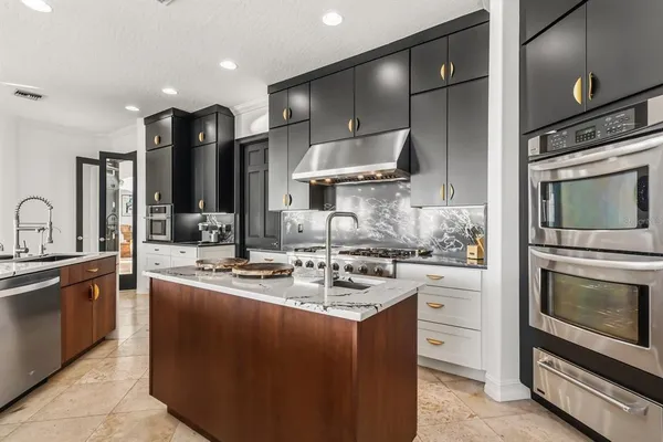 a kitchen with stainless steel appliances granite countertop a stove and a refrigerator
