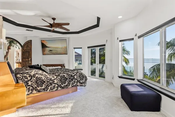 a spacious bedroom with a bed and glass windows