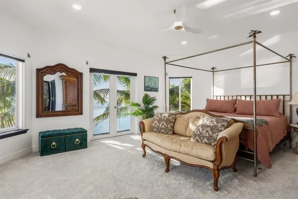 a bedroom with a bed flat screen tv and a large window