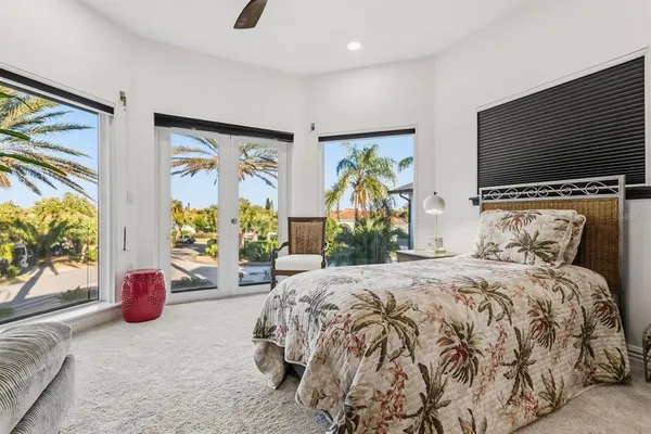 a view of a white building with couches and dinning table under an umbrella