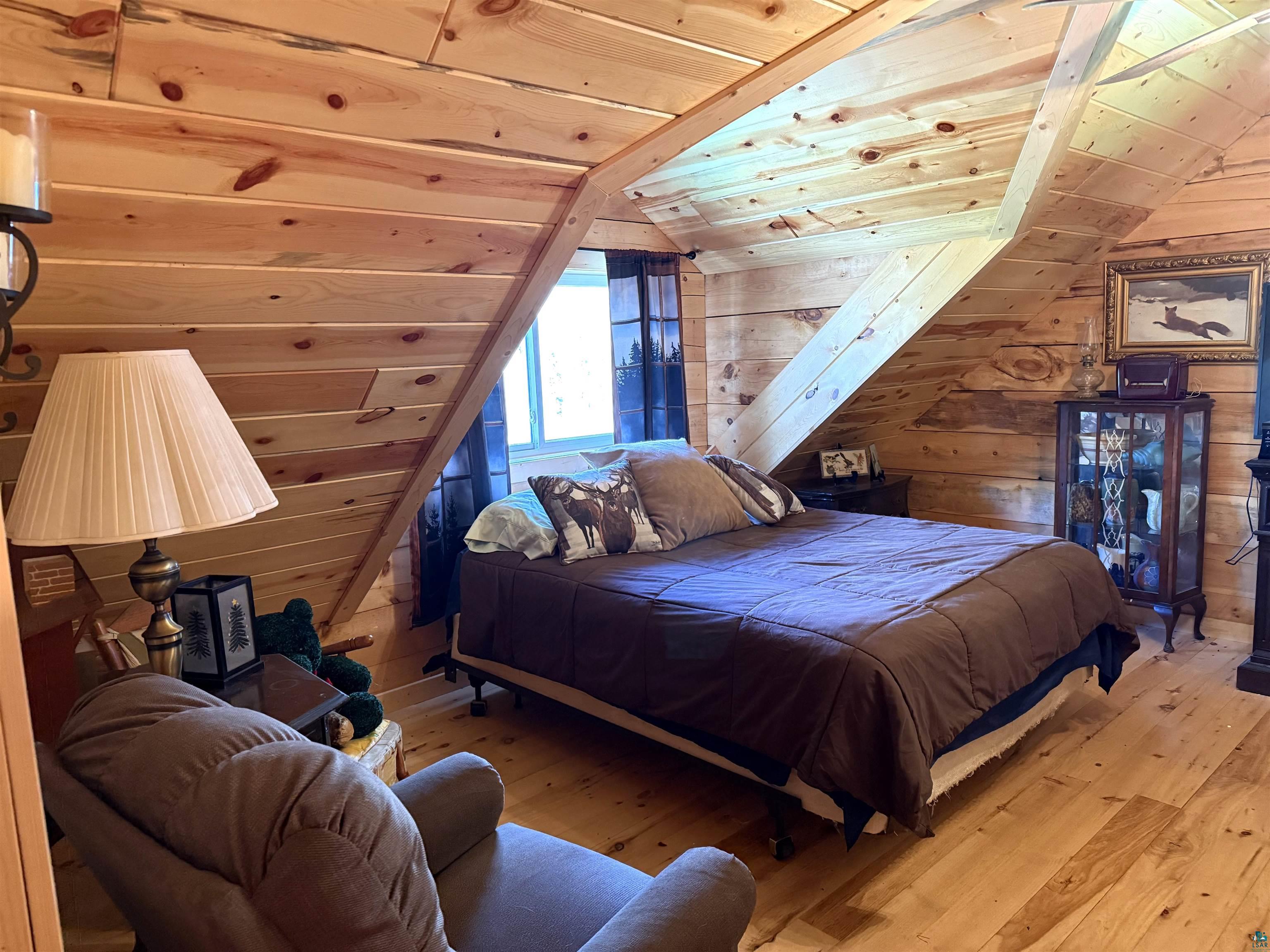 37590 Degerstrom Road Askov, MN 55704 - Photo 23 of 53 Wood-paneled room featuring sloped ceilings and exposed beams