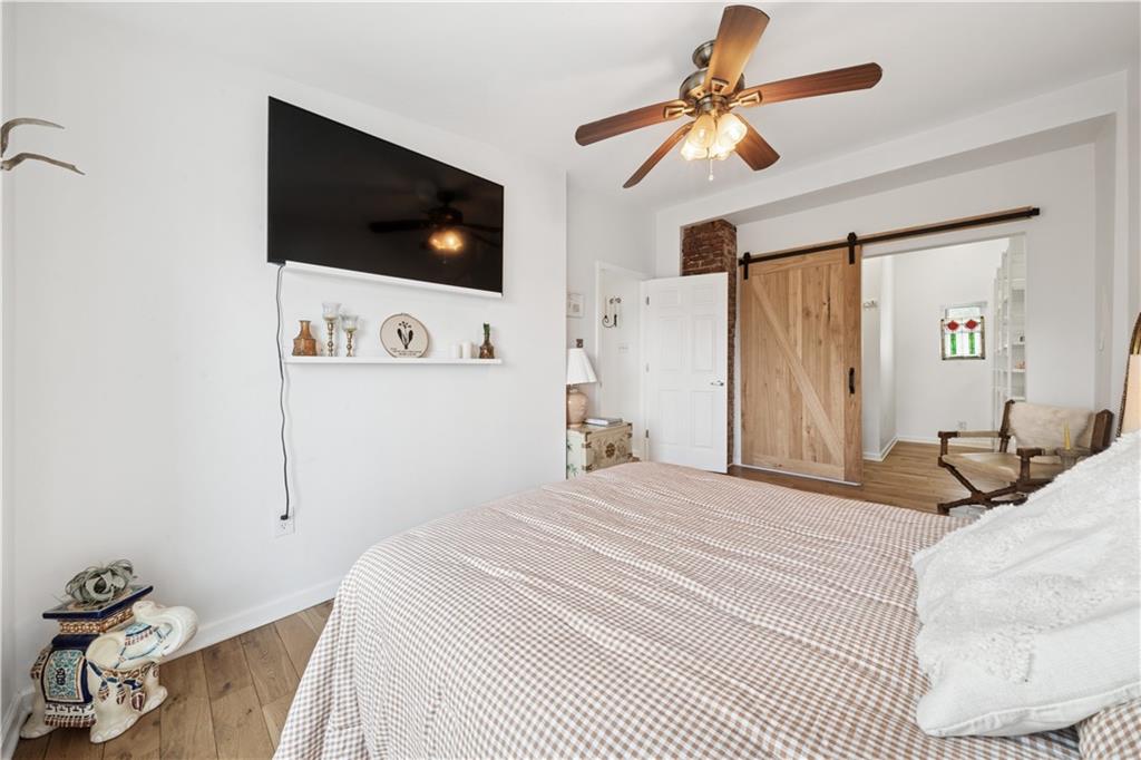 154 Henderson Street Pittsburgh, PA 15212 - Photo 16 of 31 a bedroom with a bed a flat screen tv and a chandelier