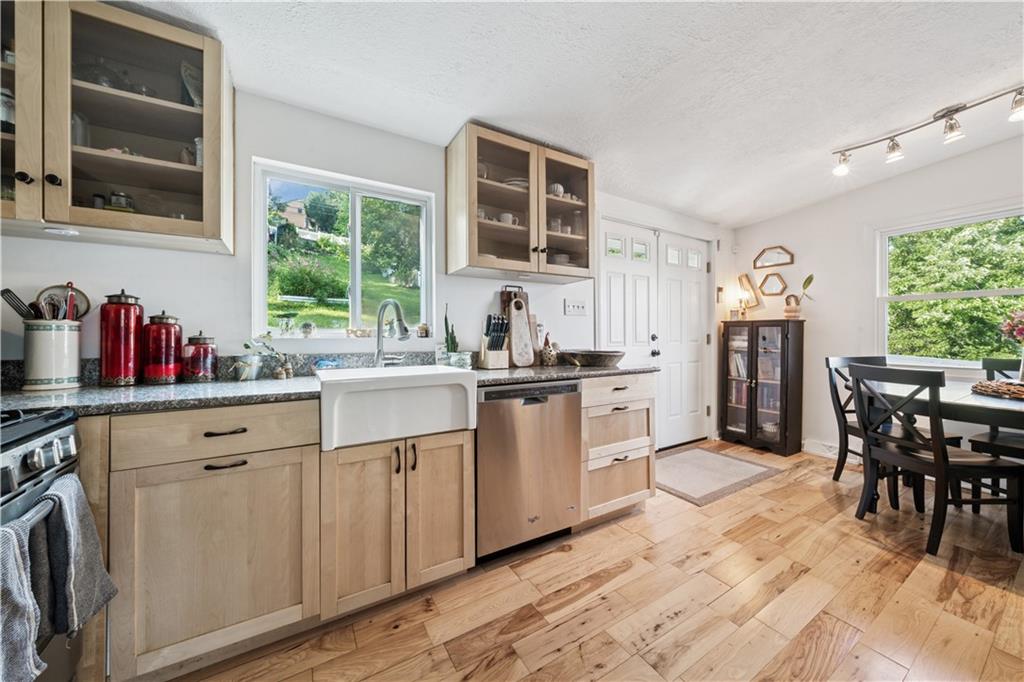 154 Henderson Street Pittsburgh, PA 15212 - Photo 7 of 31 a kitchen with white cabinets and dining table with wooden floor