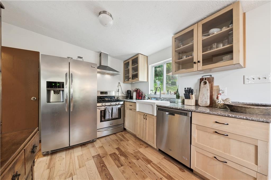 154 Henderson Street Pittsburgh, PA 15212 - Photo 8 of 31 a kitchen with granite countertop a refrigerator and wooden cabinets