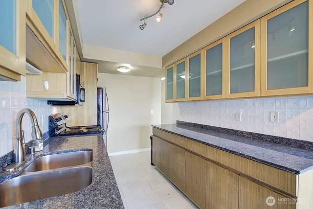a kitchen with stainless steel appliances granite countertop a sink stove and cabinets