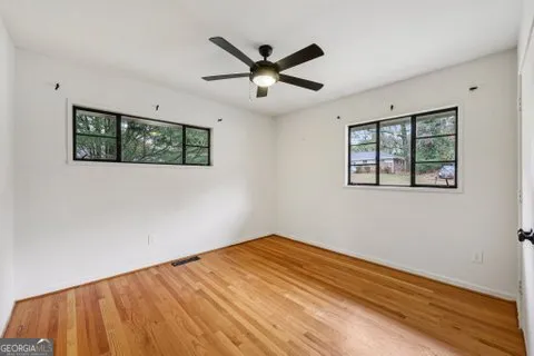 a view of empty room with wooden floor