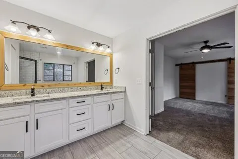 a bathroom with a granite countertop sink vanity and mirror