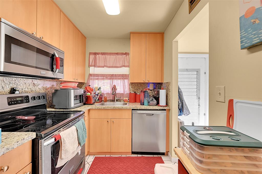 2811 North Pine Island Road, Unit 111 Sunrise, FL 33322 - Photo 11 of 13 a kitchen with a stove a sink and a microwave
