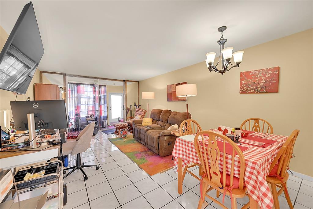 2811 North Pine Island Road, Unit 111 Sunrise, FL 33322 - Photo 7 of 13 a living room with furniture a flat screen tv and kitchen view