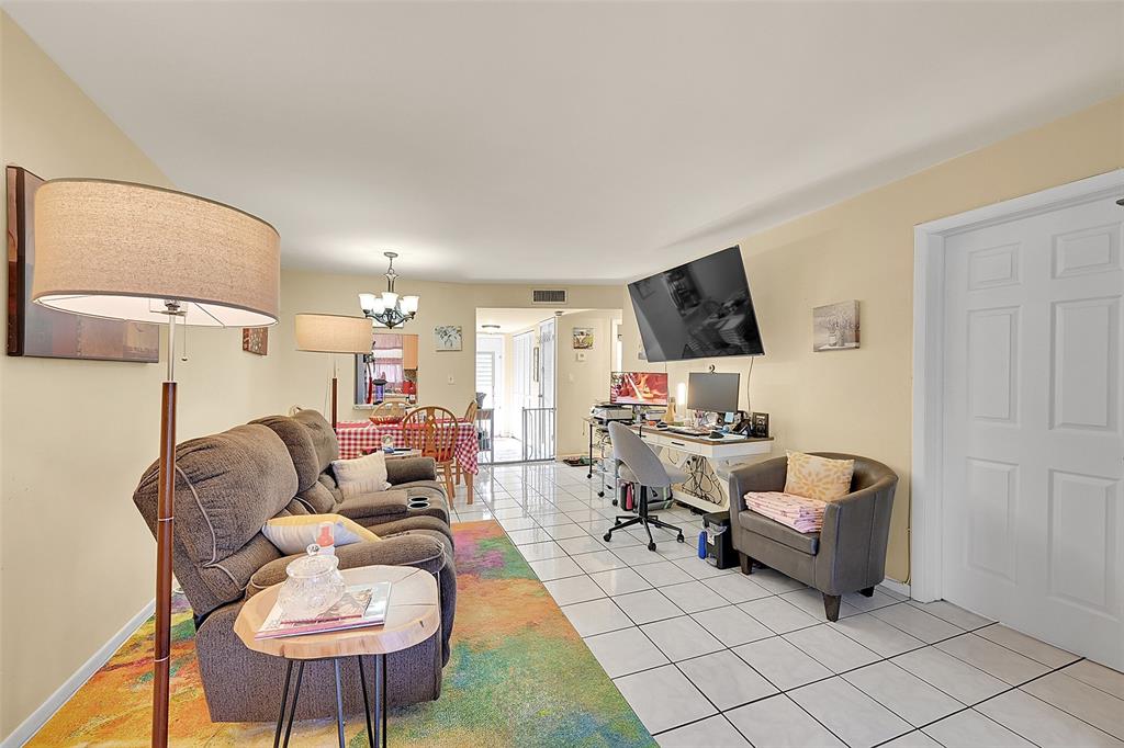 2811 North Pine Island Road, Unit 111 Sunrise, FL 33322 - Photo 9 of 13 a living room with furniture and a flat screen tv