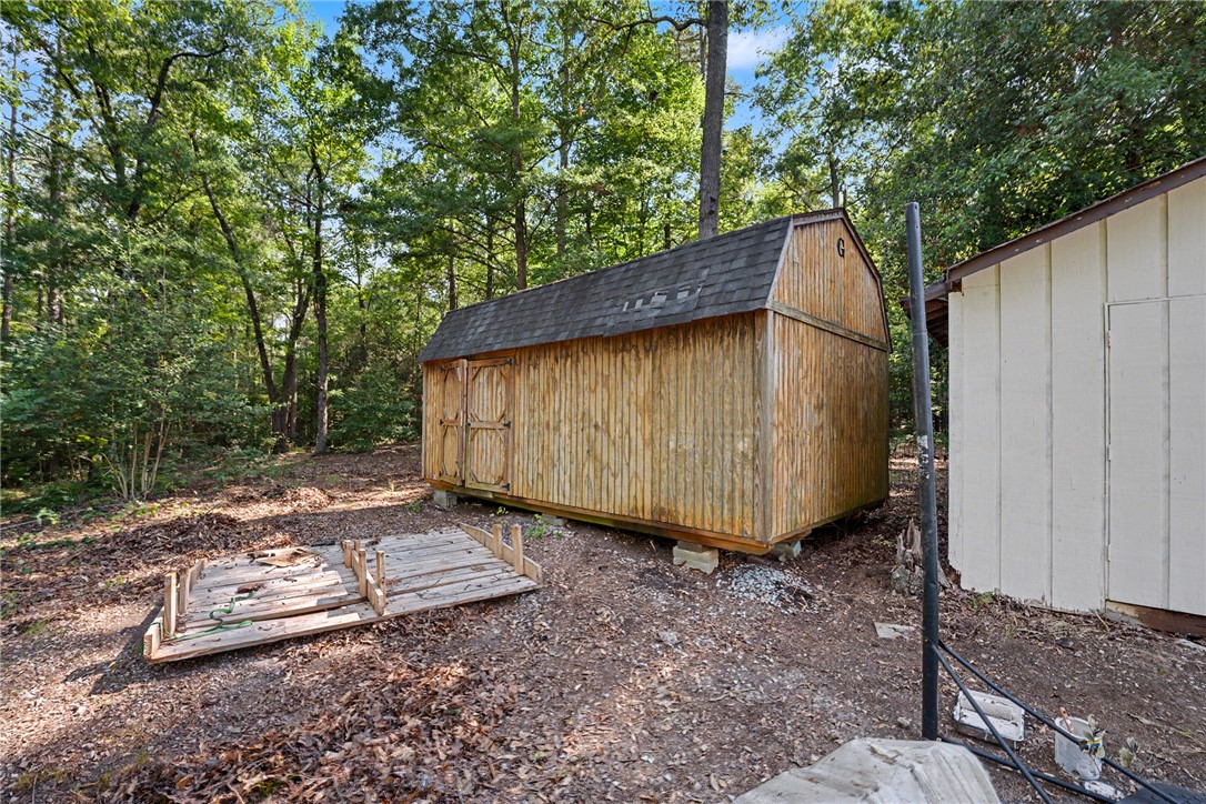 266 Ledford Farm Road Fair Play, SC 29643 - Photo 7 of 34 A rustic wooden shed provides ample storage amidst a tranquil, wooded setting.