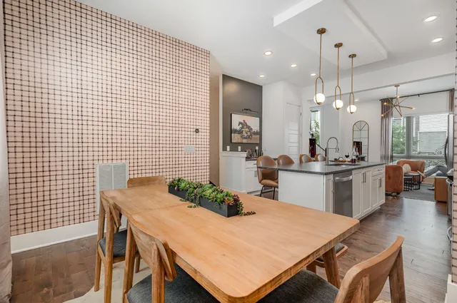 a kitchen with a dining table chairs and white cabinets