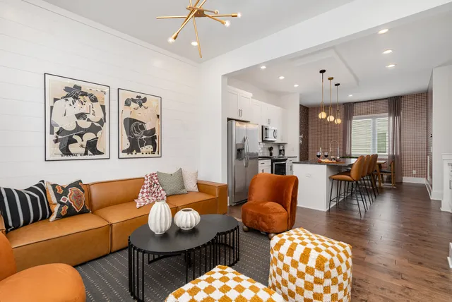 a living room with furniture kitchen view and a chandelier
