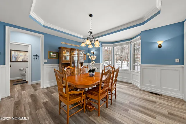 a view of a dining room with furniture large windows and wooden floor