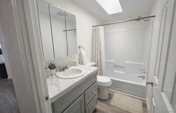 a bathroom with a granite countertop sink toilet and shower