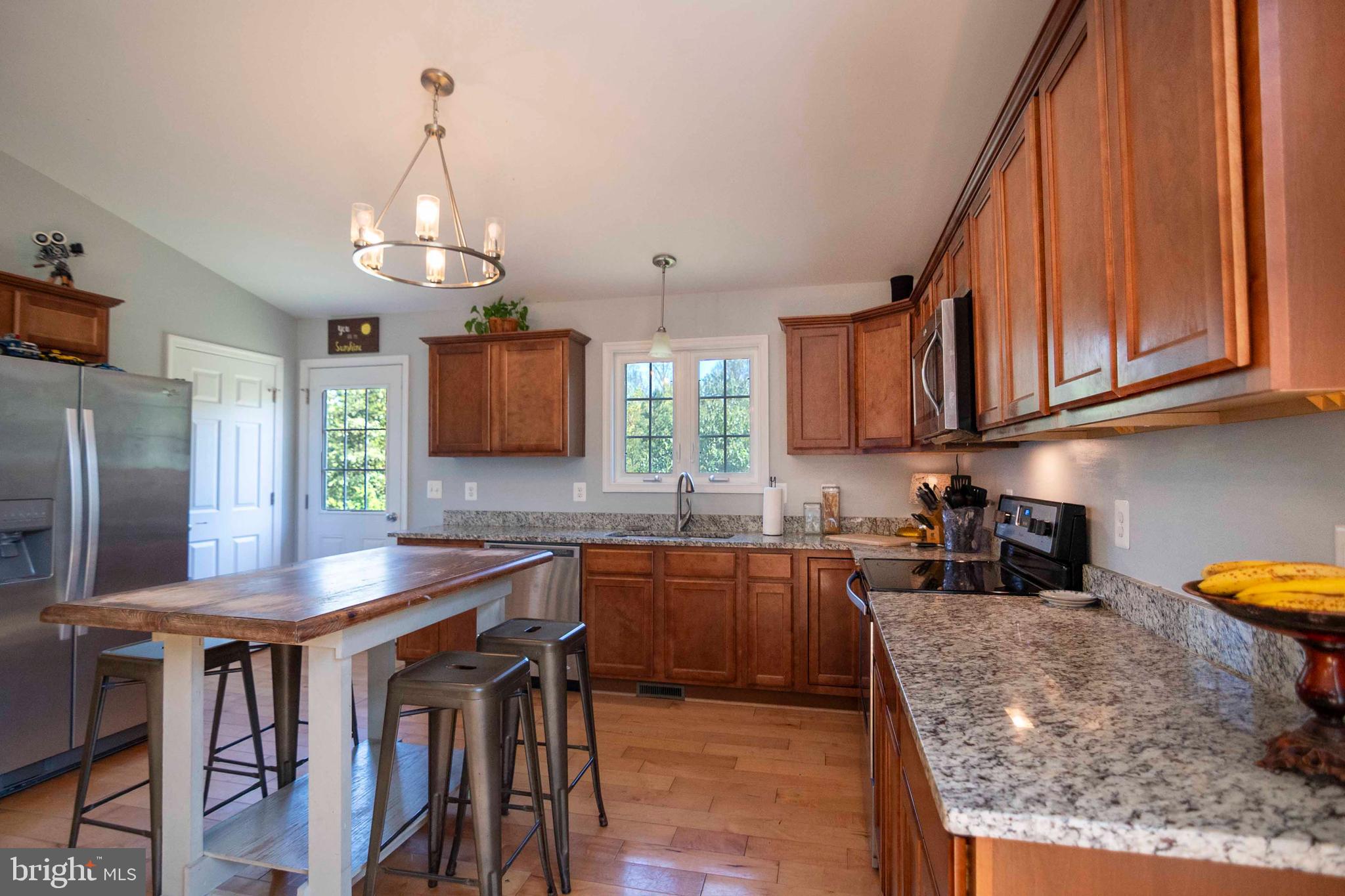 21281 Old Mill Road Culpeper, VA 22701 - Photo 26 of 40 a kitchen with stainless steel appliances granite countertop a sink a stove and a wooden floors