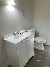 a bathroom with a sink toilet and a mirror