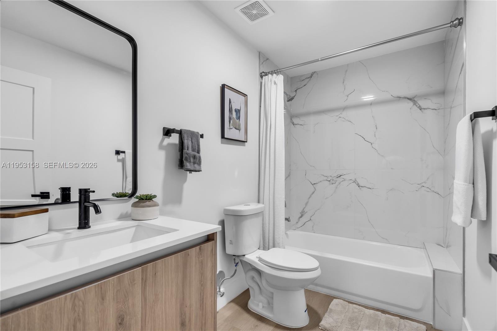 3728 Northwest 19th Avenue, Unit 304 Miami, FL 33142 - Photo 20 of 26 a bathroom with a sink a toilet and a mirror