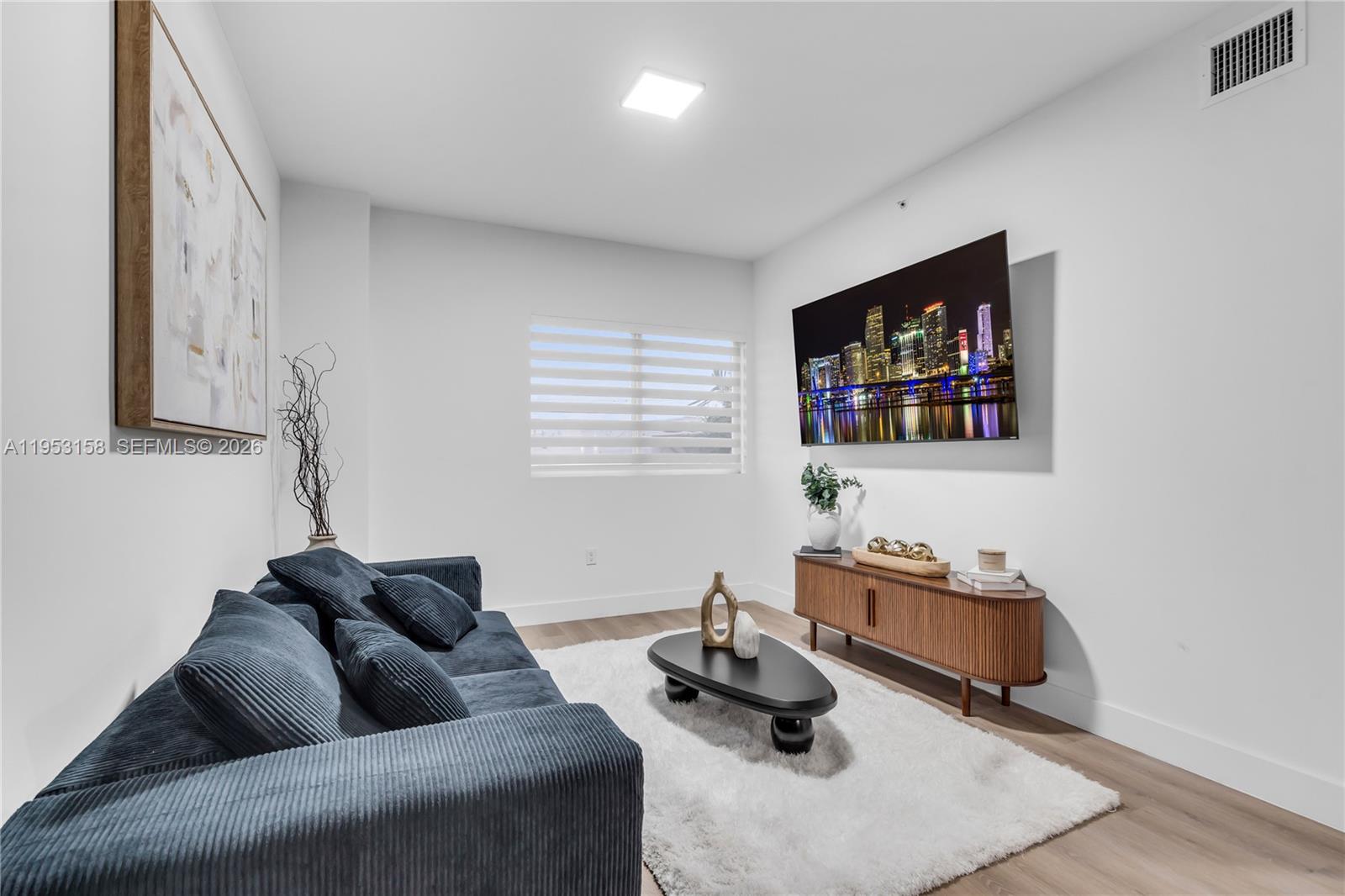 3728 Northwest 19th Avenue, Unit 304 Miami, FL 33142 - Photo 3 of 26 a living room with furniture and a flat screen tv