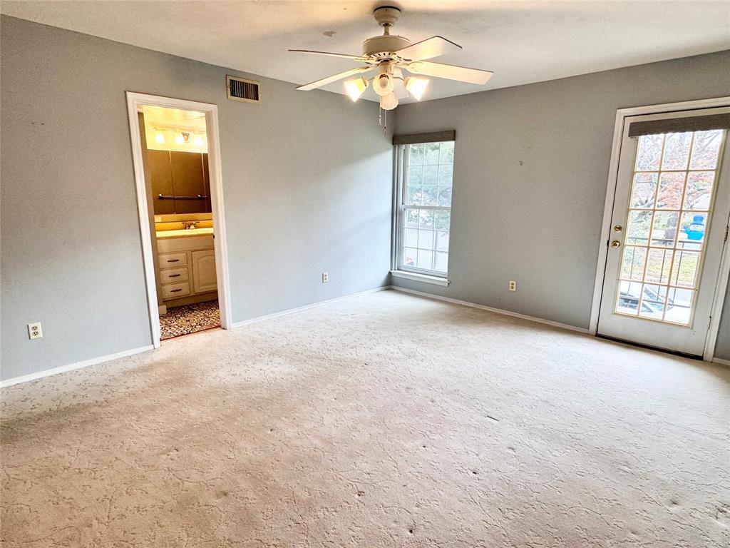 4014 Ridglea Country Club Drive, Unit 407 Fort Worth, TX 76126 - Photo 17 of 26 an empty room with windows and chandelier fan