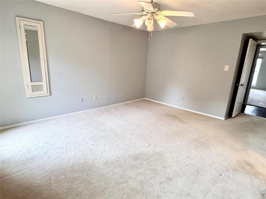 4014 Ridglea Country Club Drive, Unit 407 Fort Worth, TX 76126 - Photo 19 of 26 an empty room with a chandelier fan and windows