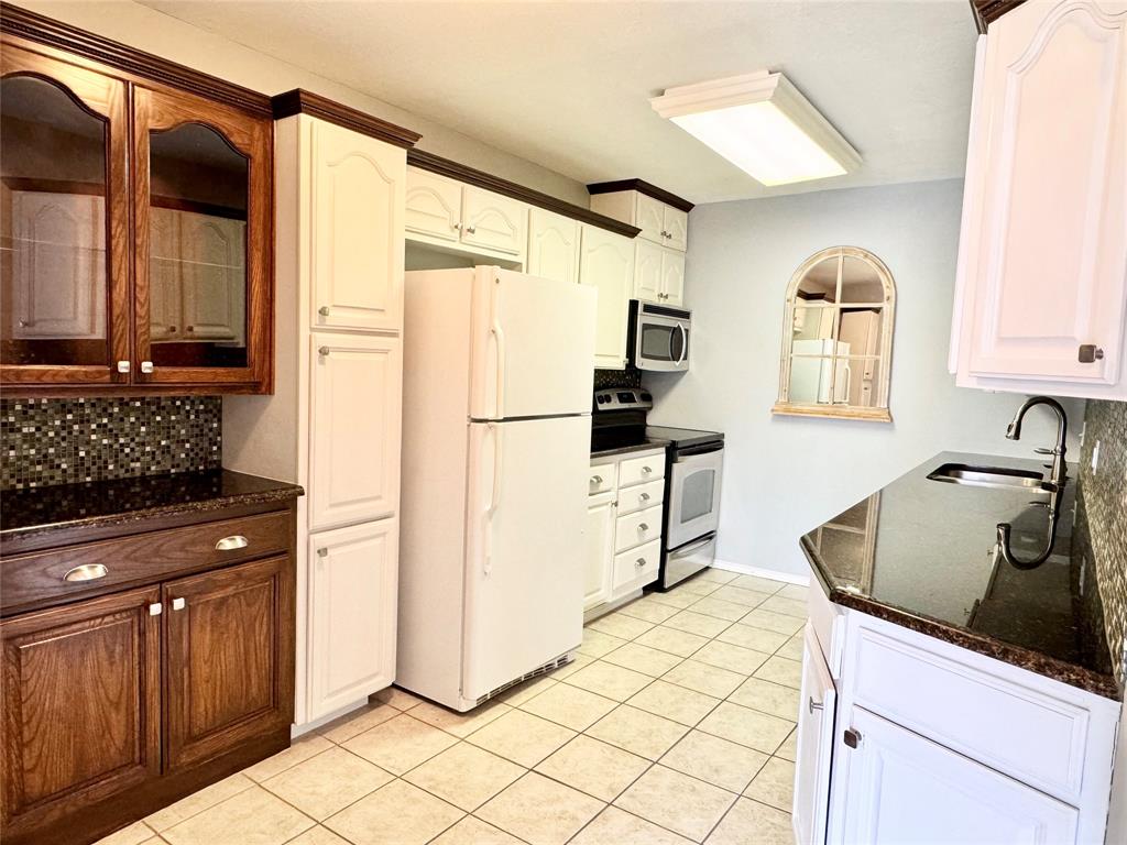 4014 Ridglea Country Club Drive, Unit 407 Fort Worth, TX 76126 - Photo 6 of 26 a kitchen with granite countertop a refrigerator and a sink