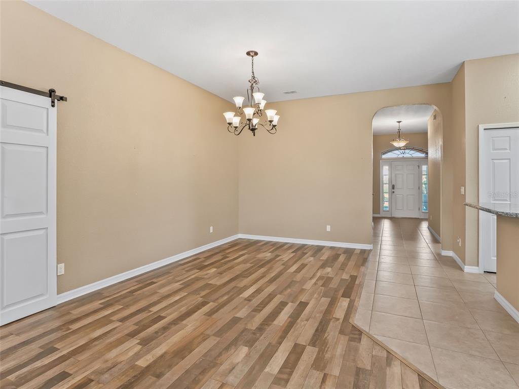 16896 South East 110th Court Road Summerfield, FL 34491 - Photo 15 of 61 a view of a room with a chandelier and wooden floor